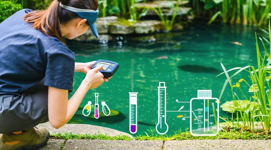A person using a handheld water quality meter by a clear backyard pond, surrounded by lush greenery, representing the blend of professional water management techniques in a home setting.